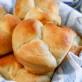 multiple dinner rolls in a bread basket.