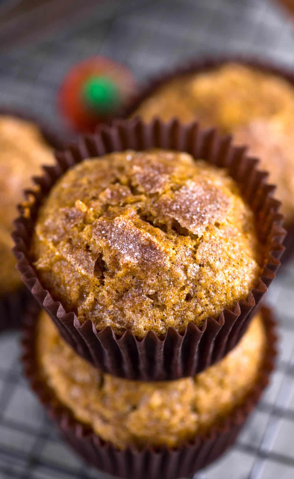 pumpkin muffins stacked in brown cupcake wrappers.