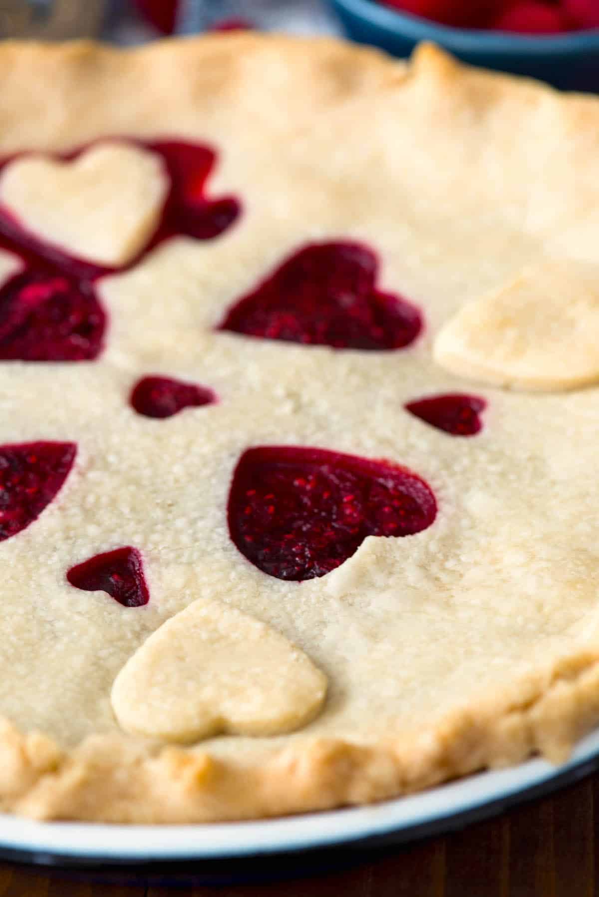 one slice of pie with raspberry filling and a heart sliced out of the dough.
