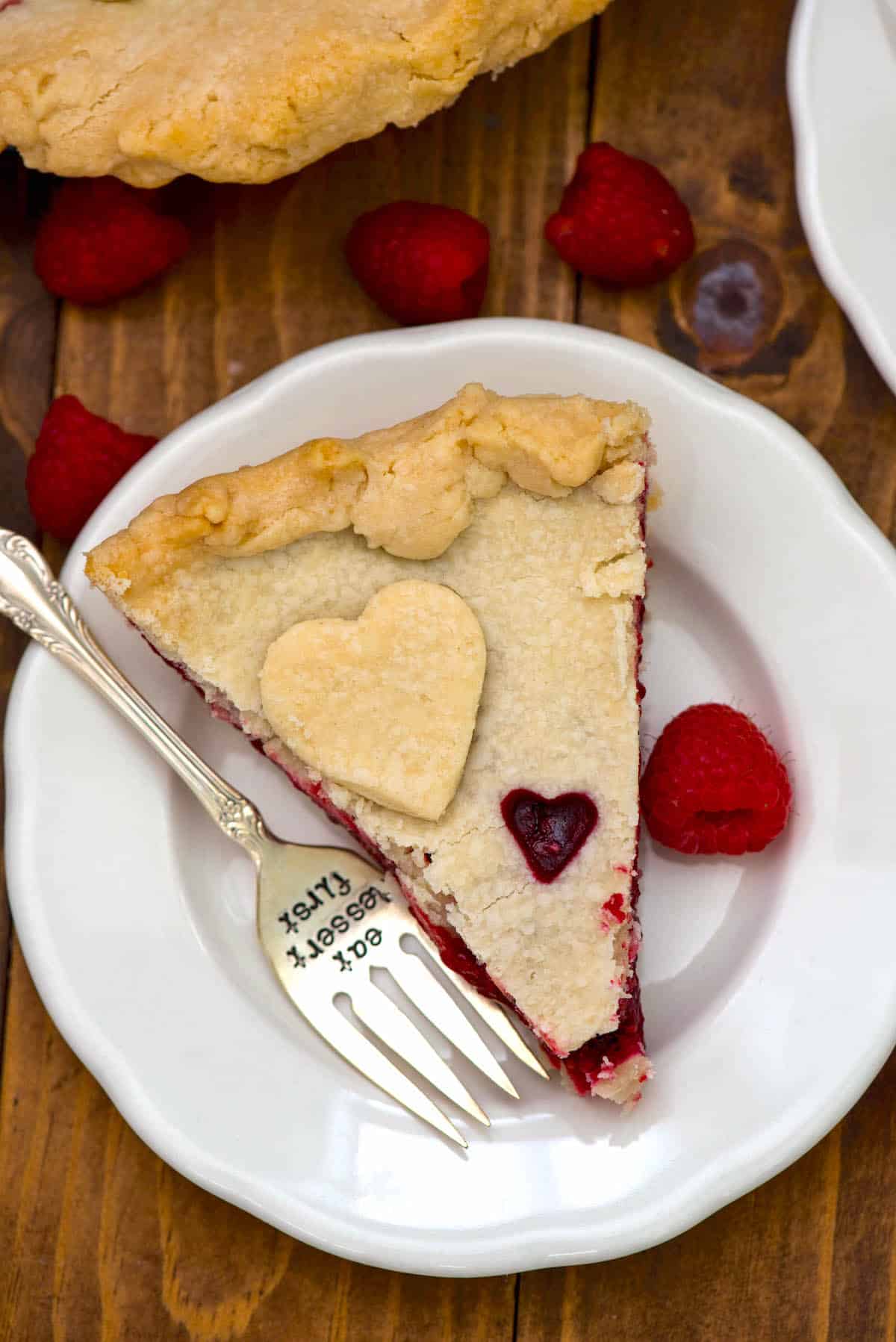 one slice of pie with raspberry filling and a heart sliced out of the dough.