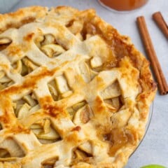 Apple pie with lattice top in a clear pie plate.