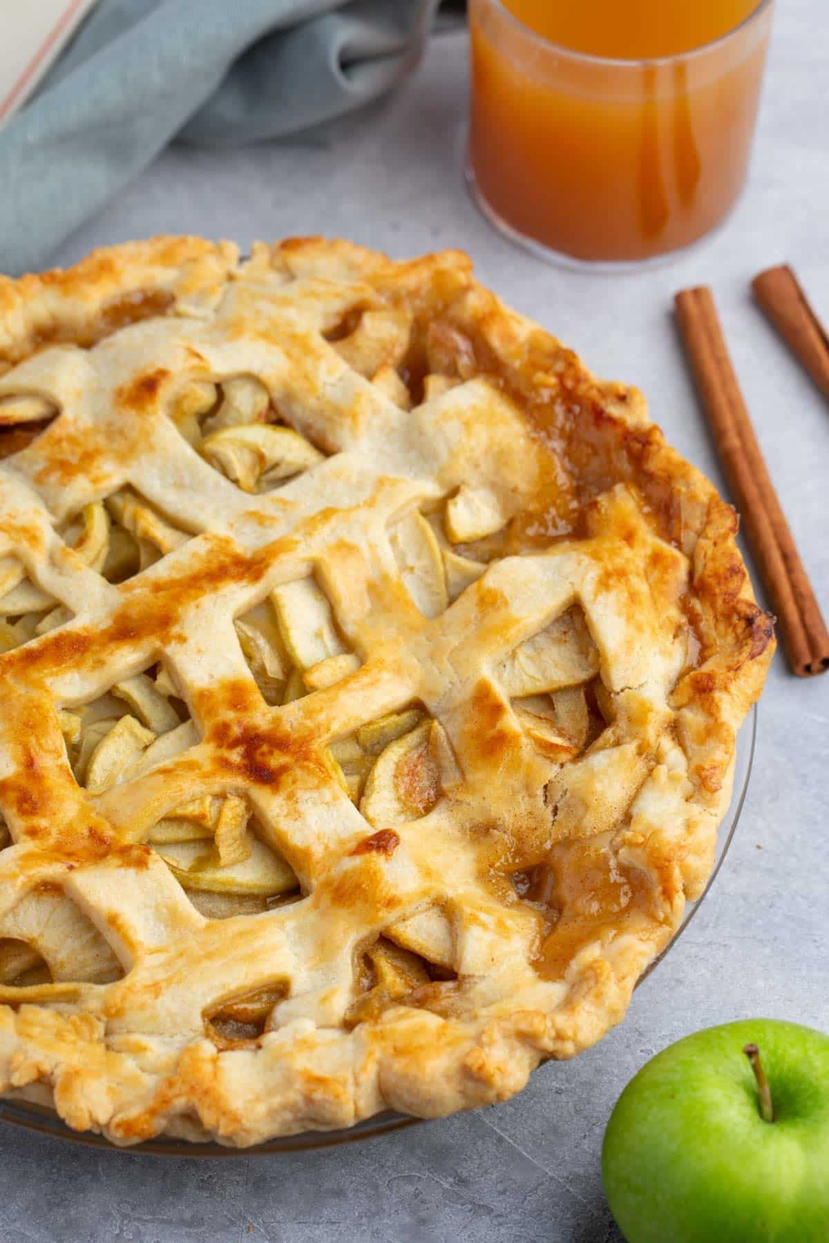 Apple pie with lattice top in a clear pie plate.