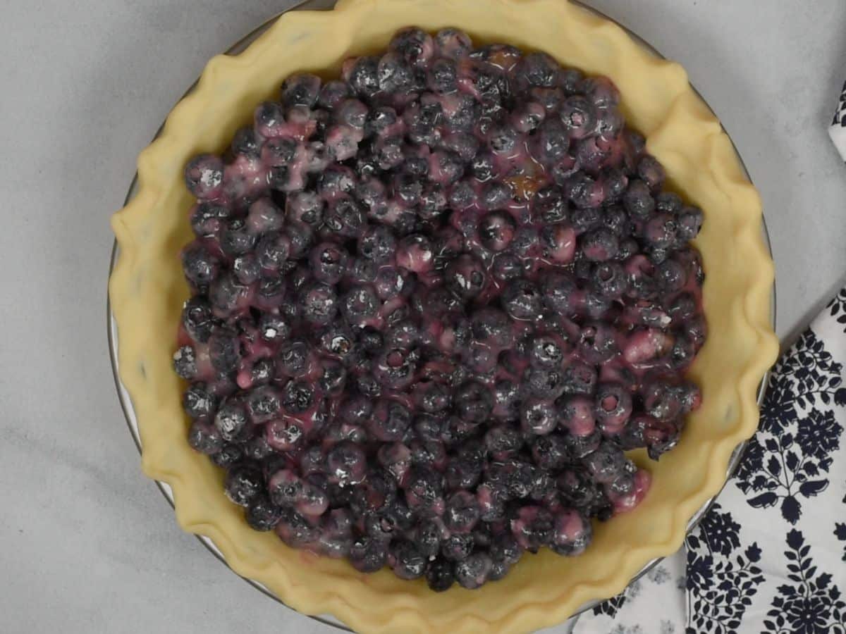 process shot of the making of blueberry crumble pie.