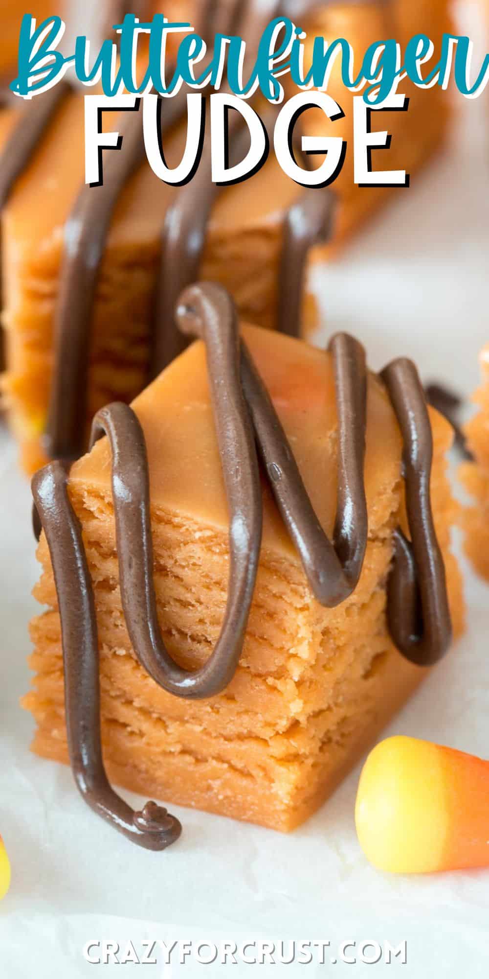orange butterfinger fudge with chocolate sauce dripped over the top and words on the image.