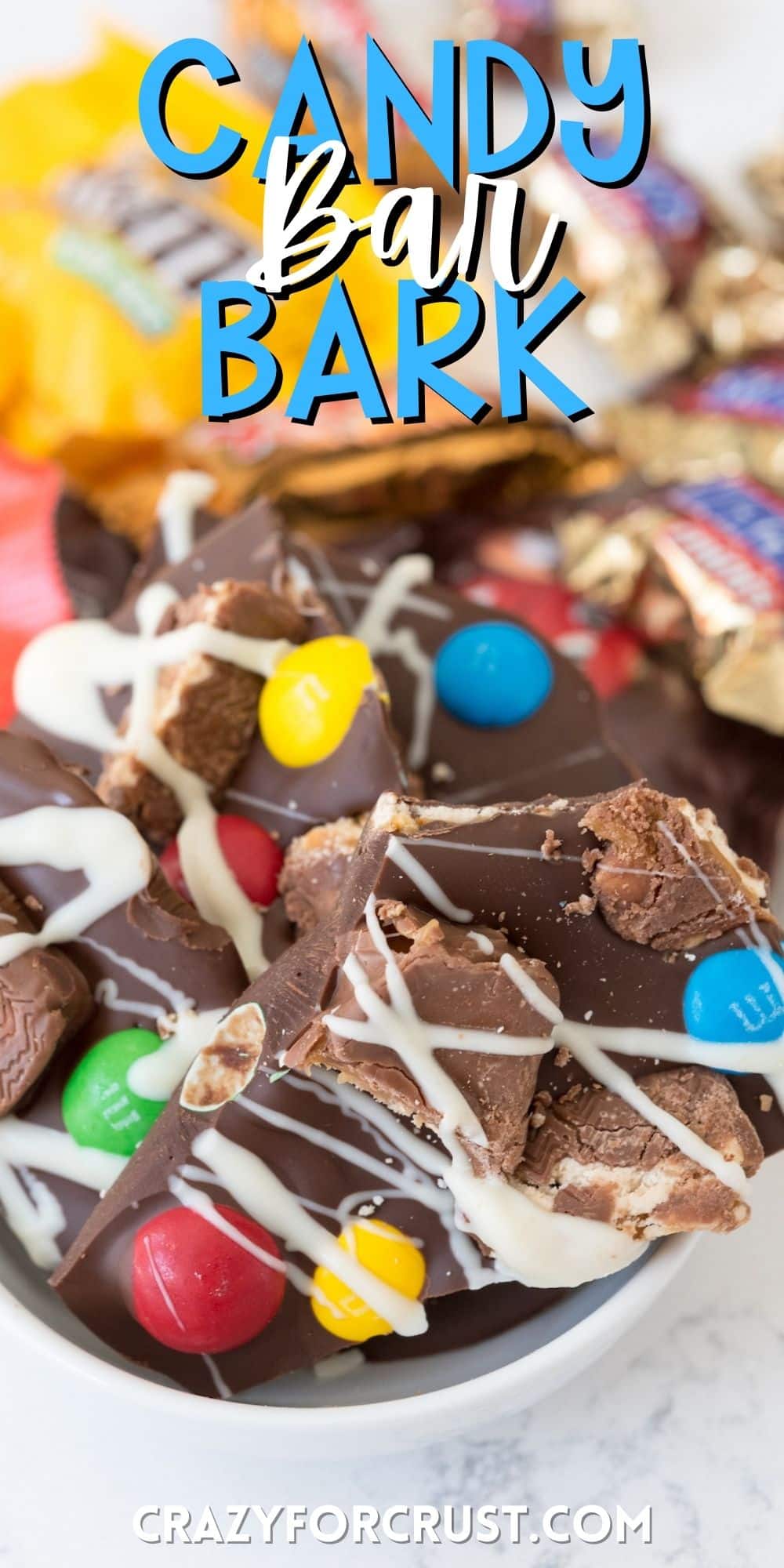 broken pieces of chocolate bark with candy attached on top in a white bowl with words on the image.