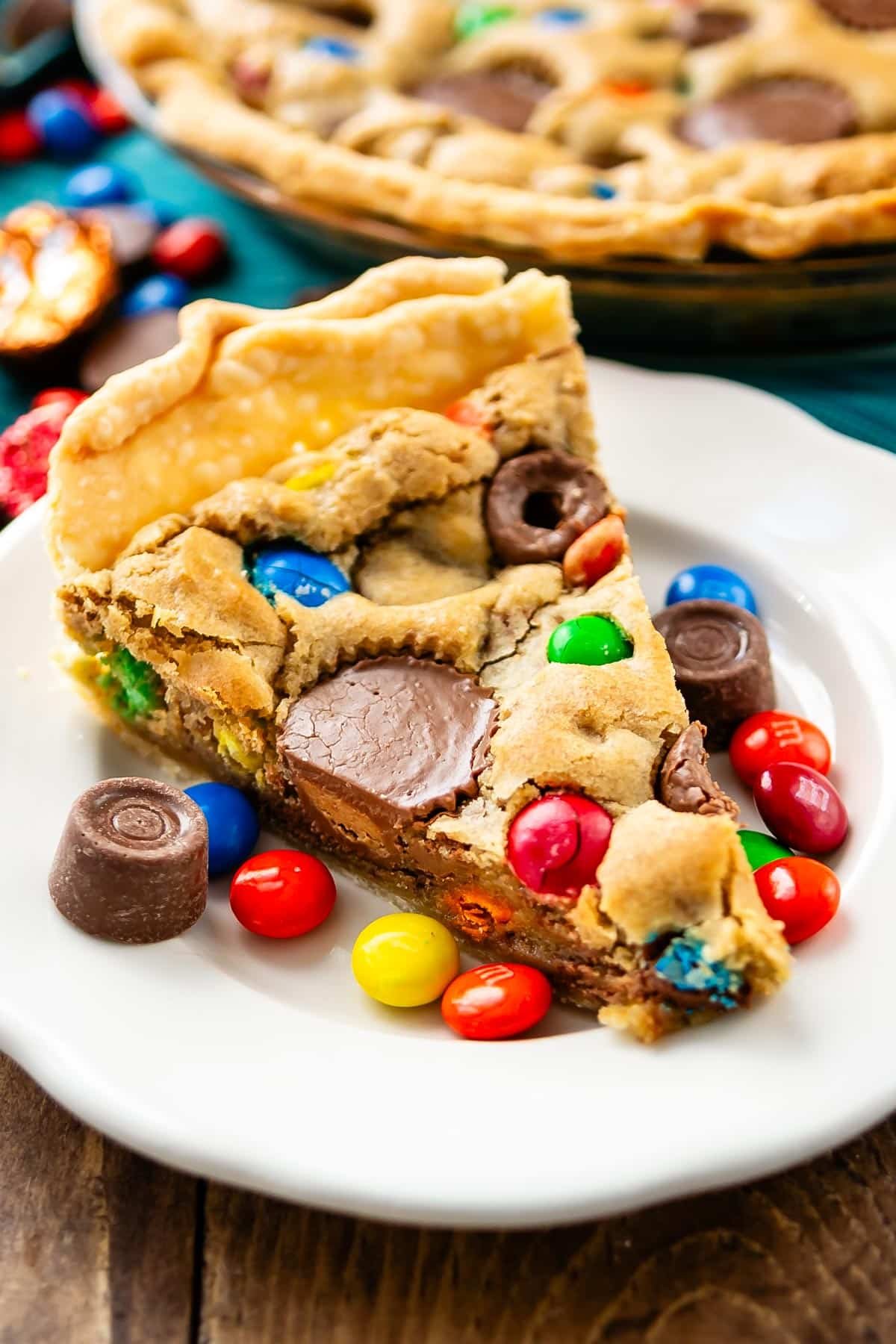 one slice of tan pie with candy baked in and candy around the pie.