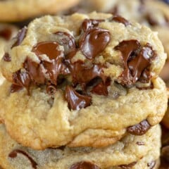 stack of chocolate chip cookies with a half cookie on top showing gooey chocolate chips