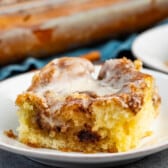 one square slice of cinnamon roll on a white plate.