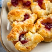 puff pastry with brie and cranberry baked in the middle on a grey plate.