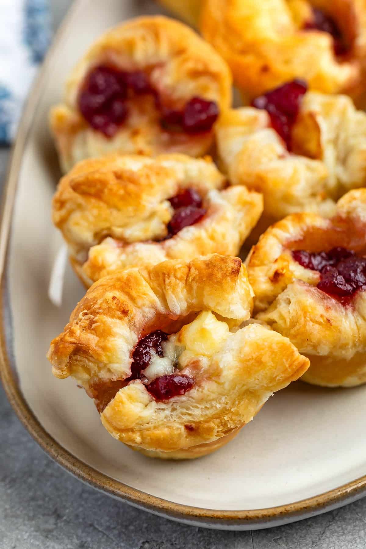 puff pastry with brie and cranberry baked in the middle on a grey plate.