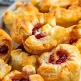 puff pastry with brie and cranberry baked in the middle on a grey plate.