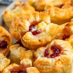 puff pastry with brie and cranberry baked in the middle on a grey plate.