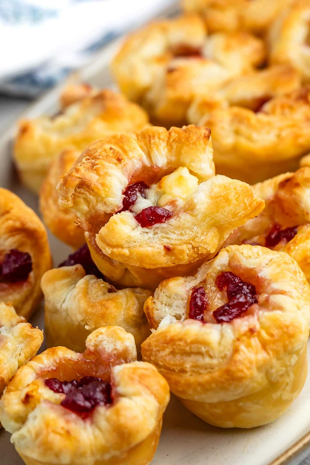 puff pastry with brie and cranberry baked in the middle on a grey plate.