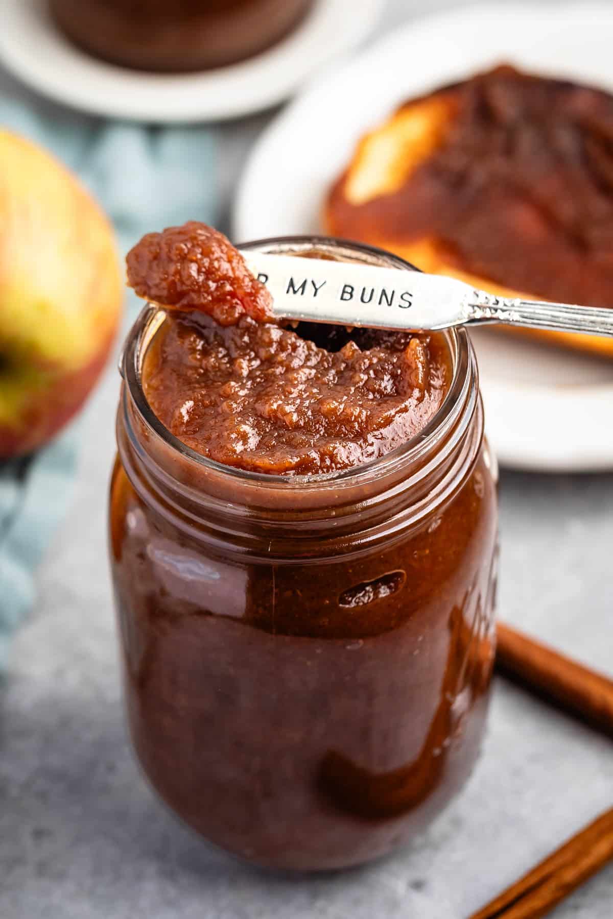 apple butter in a mason jar with a spoon scooping it.