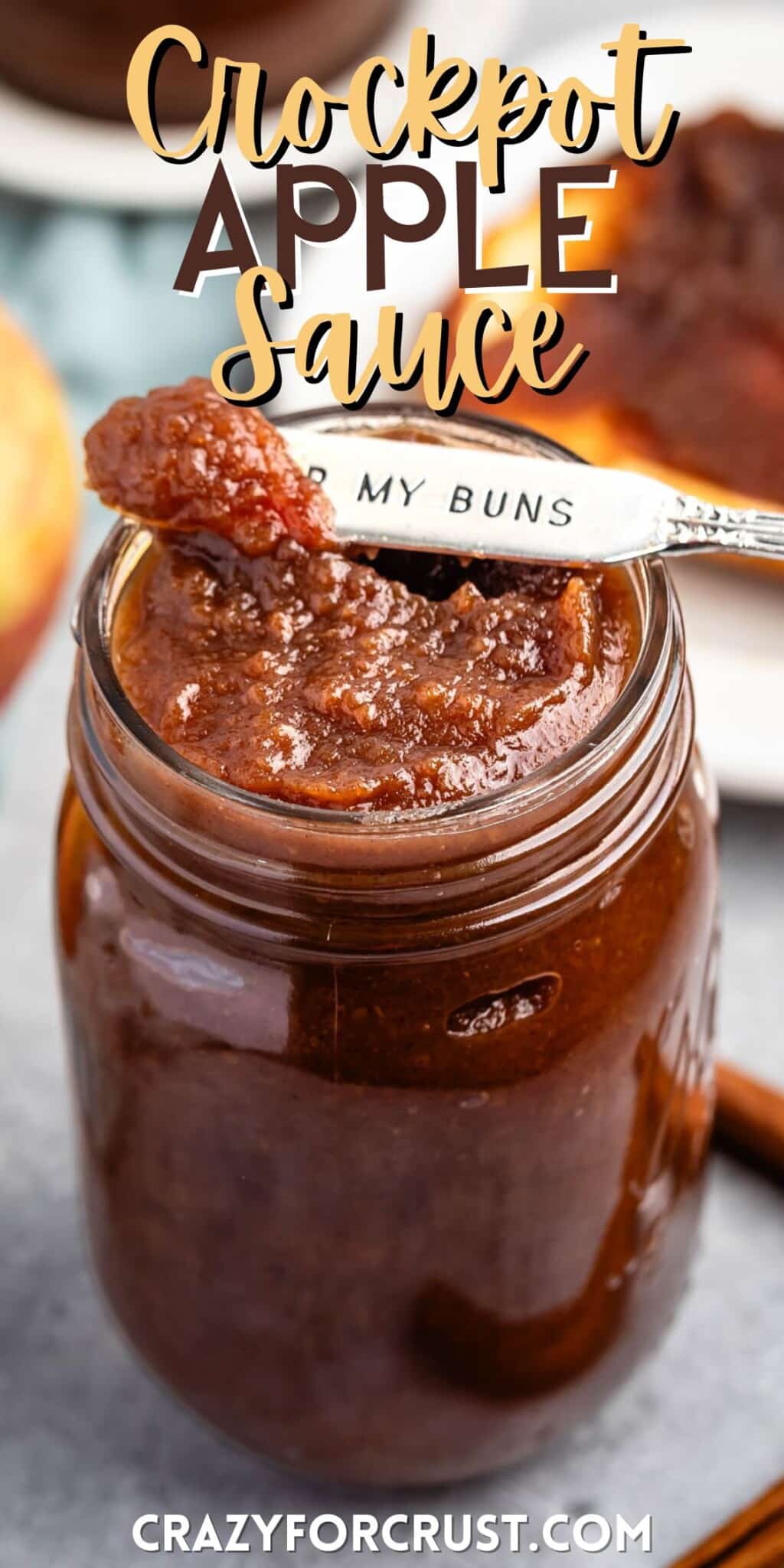 apple butter in a mason jar with a spoon scooping it with words on the image.
