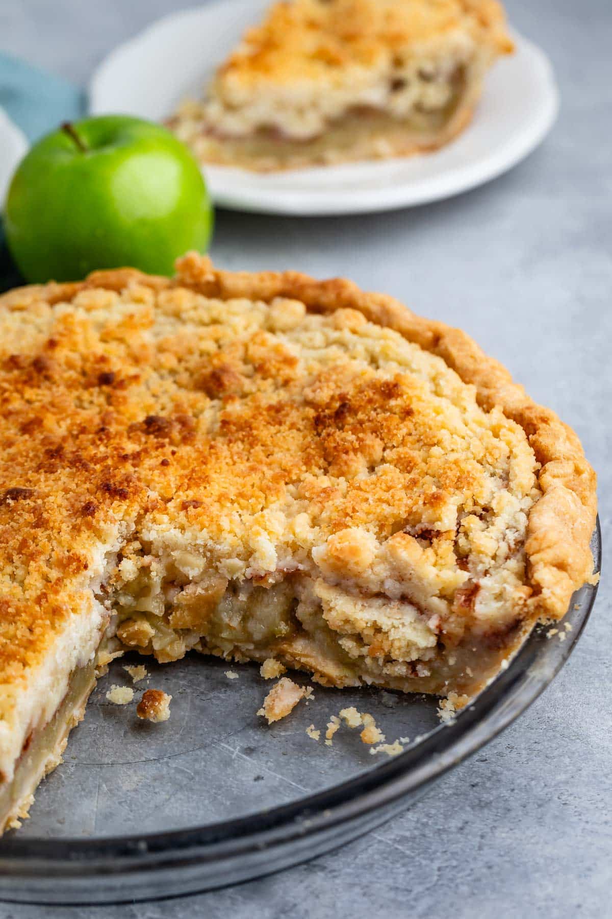 sliced pie with crumble topping in a clear pie plate.