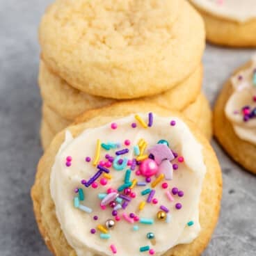 sugar cookie with white frosting and pink and blue sprinkles.