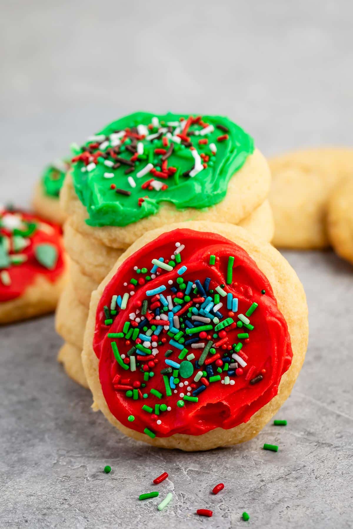 stacked cookies with green and red frosting with green and red sprinkles on top.