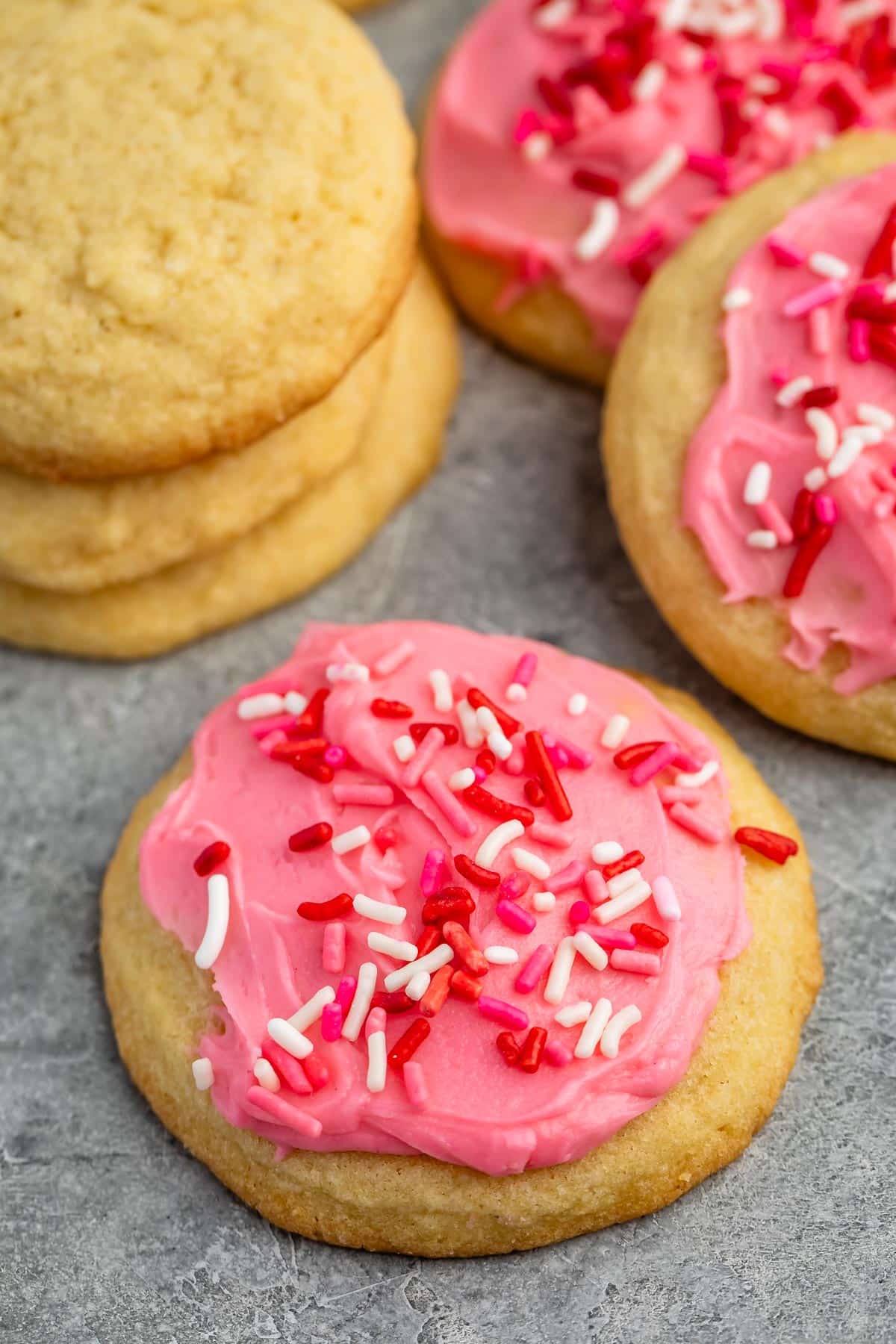 sugar cookie with pink frosting and red sprinkles.