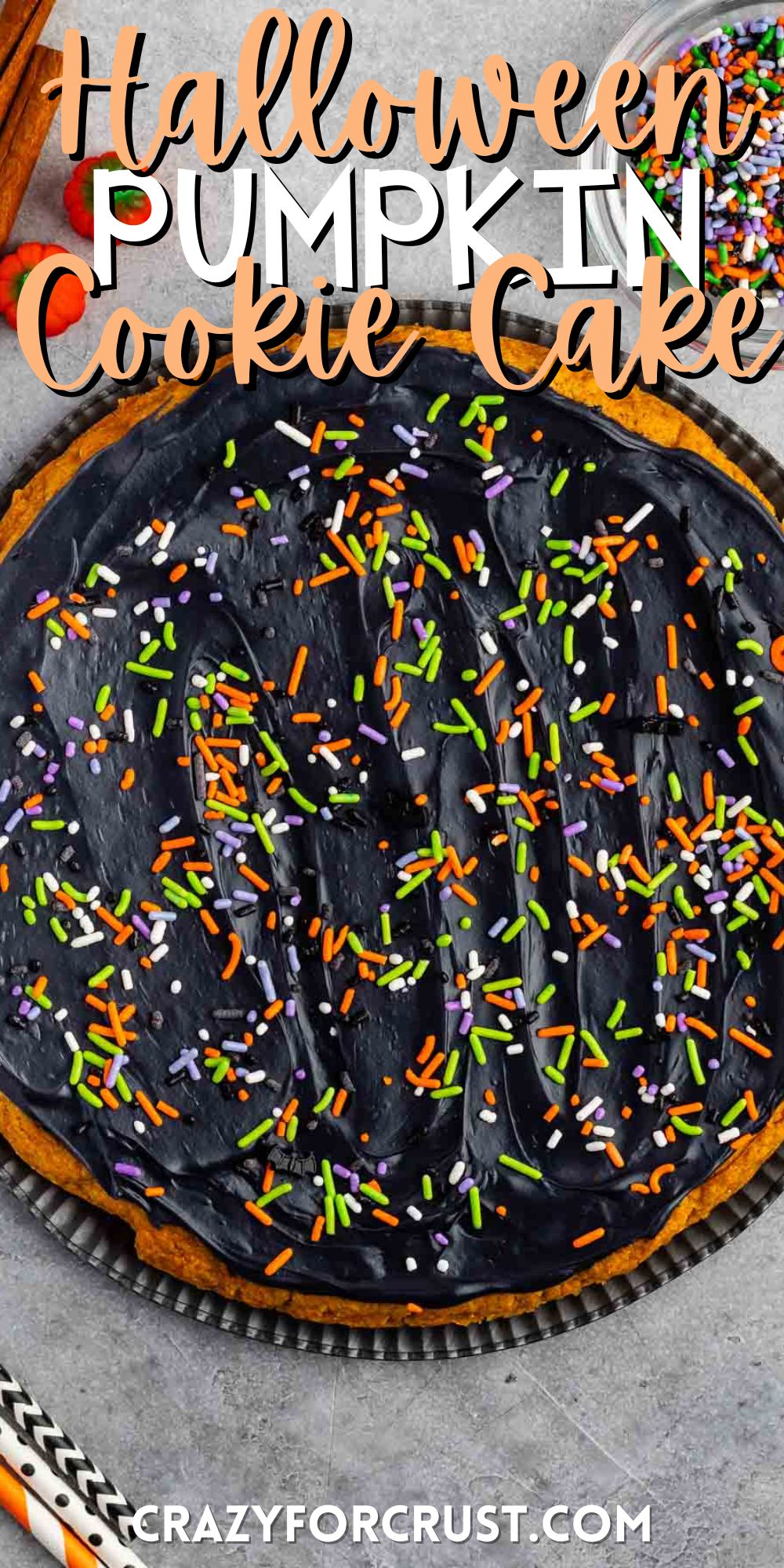halloween pumpkin cookie cake with black frosting and sprinkles on top with words on the image.