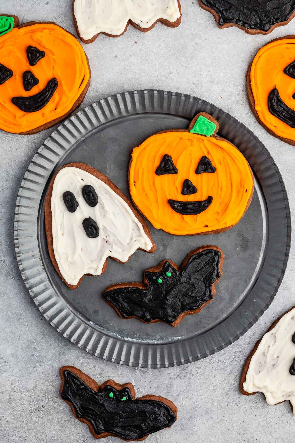 sugar cookies shaped like halloween characters and frosted with orange, white and black.