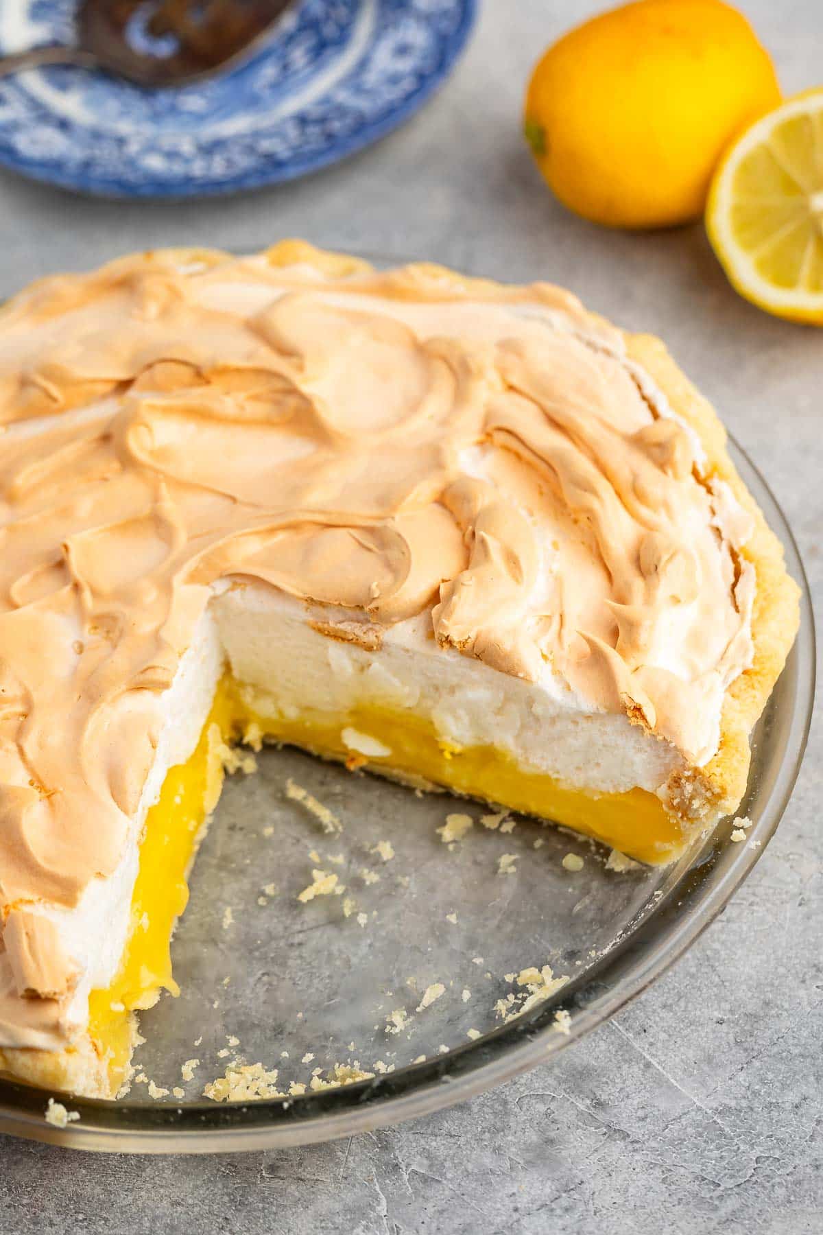 lemon pie in clear pie plate with meringue on top.