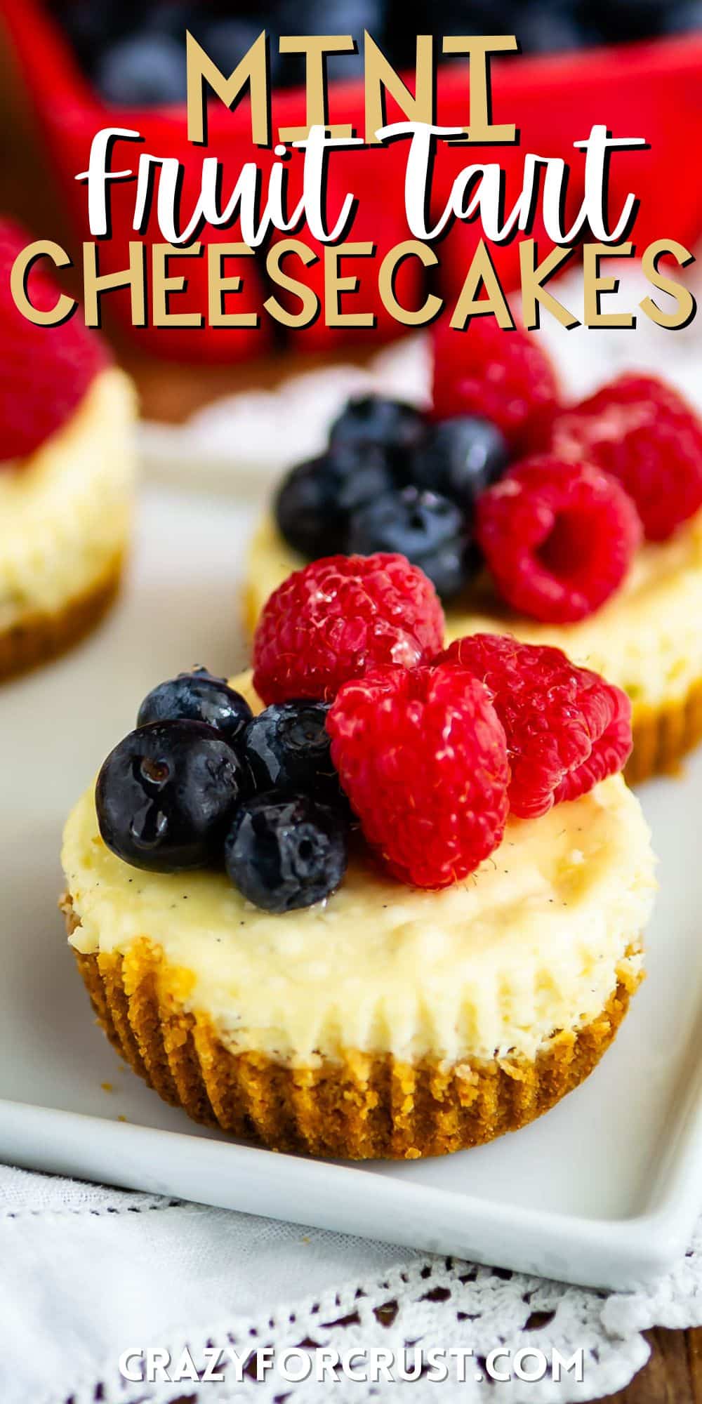 mini circular cheesecake with raspberries and blueberries on top with words on the image.