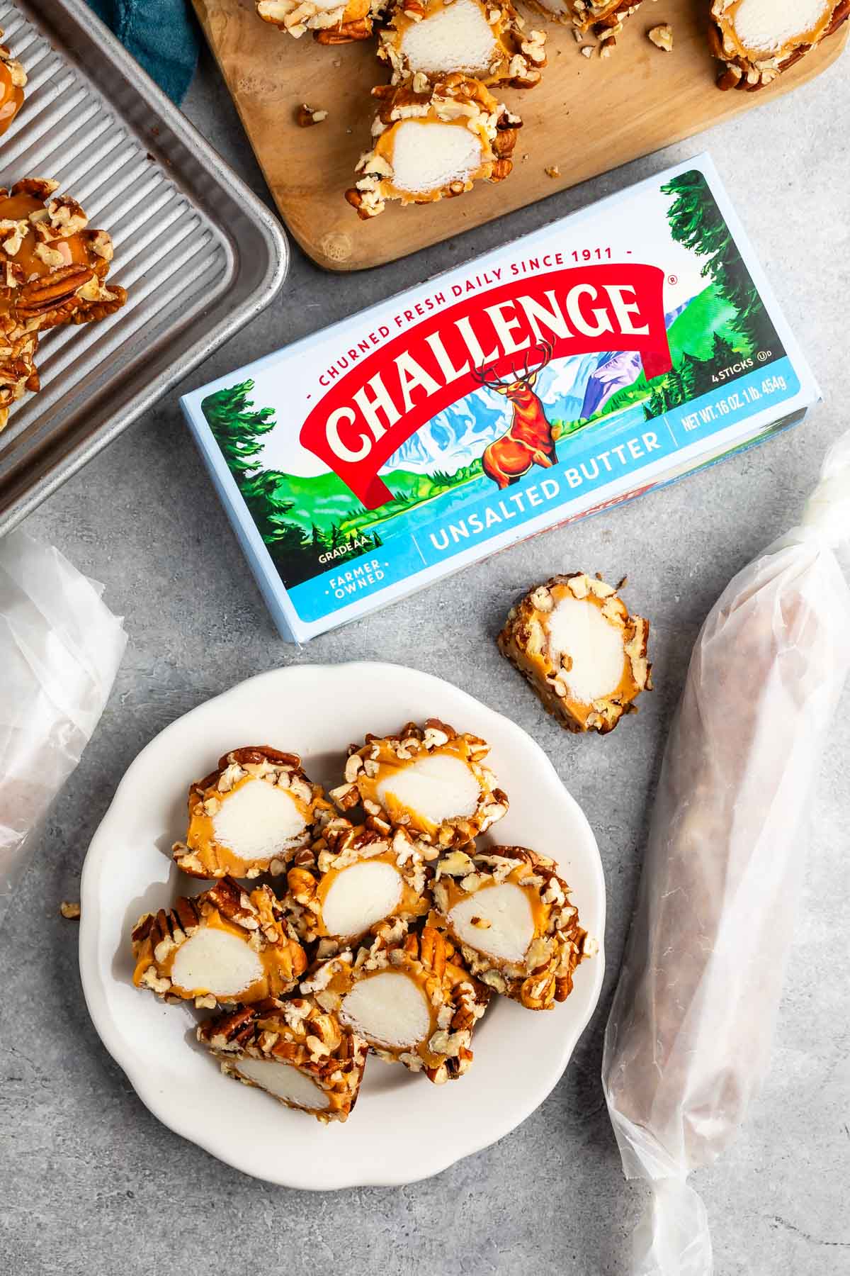 sliced pecan logs covered in caramel and pecans on a white plate.