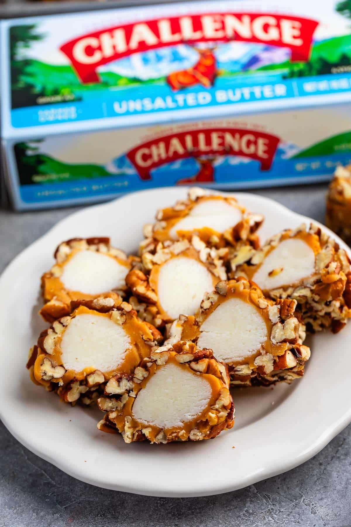 pecan log slices on white plate with challenge butter box behind