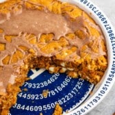 cookie pie in a white and blue pie pan with glaze drizzled over.