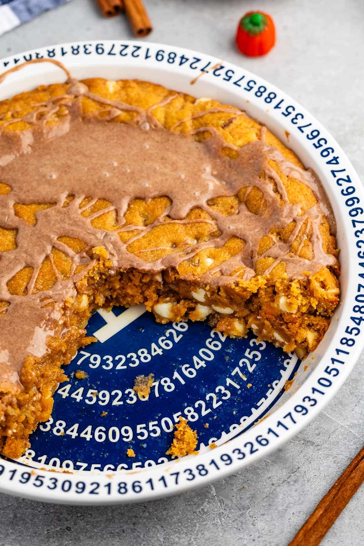 cookie pie in a white and blue pie pan with glaze drizzled over.