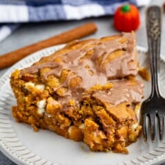 one triangle slice of pie on a grey plate with glaze drizzled over.