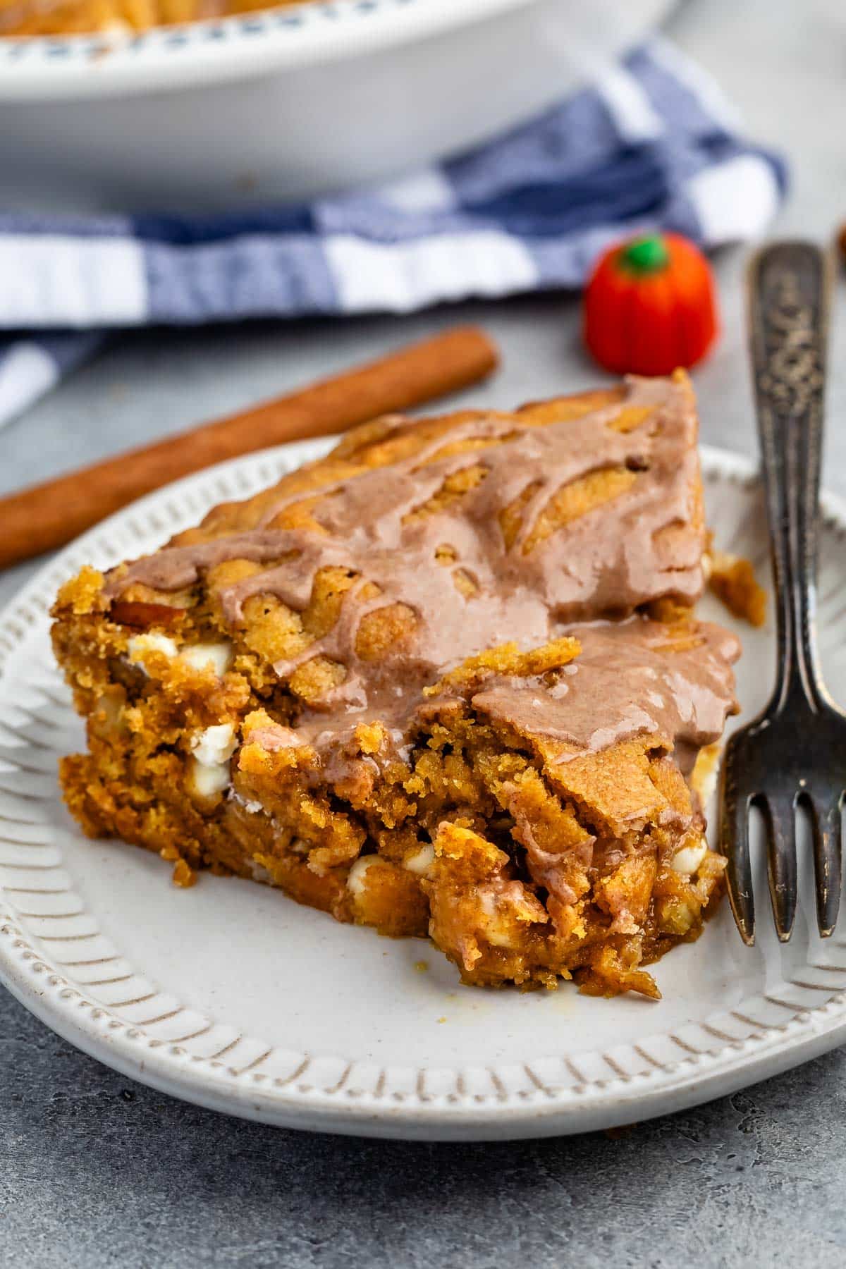 one triangle slice of pie on a grey plate with glaze drizzled over.