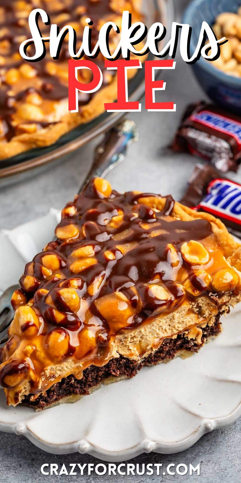 sliced snickers pie with nuts and chocolate sauce on top with words on the image.