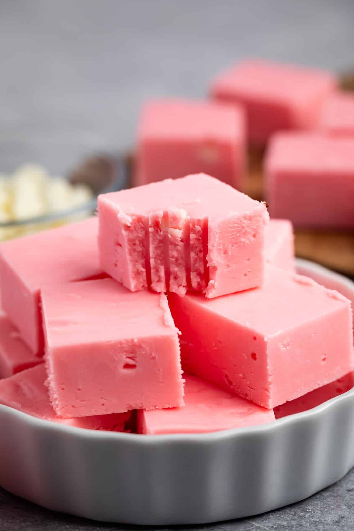 stacked pink fudge in a white dish.