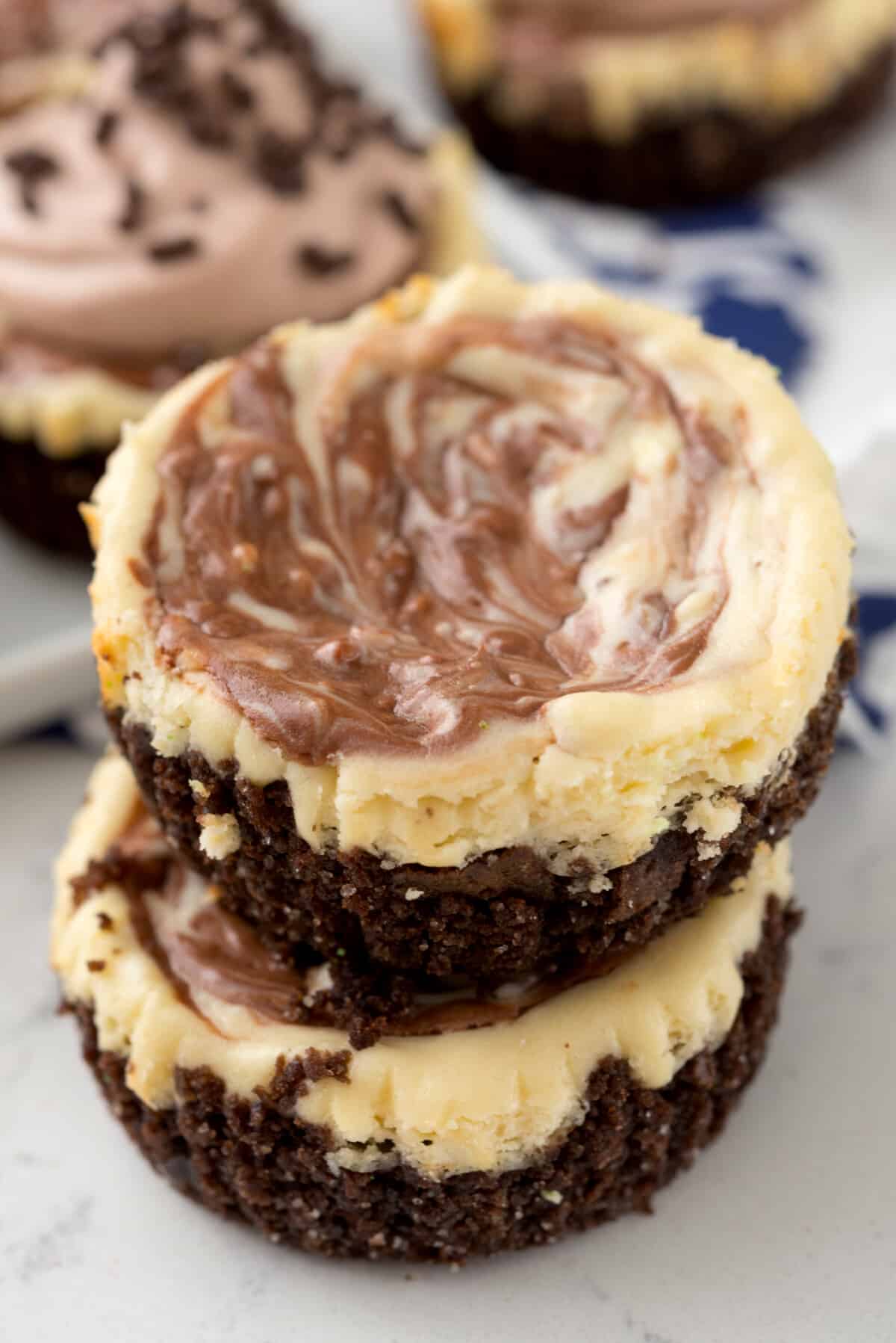 stacked mini circular cheesecakes with white and brown marble on top.