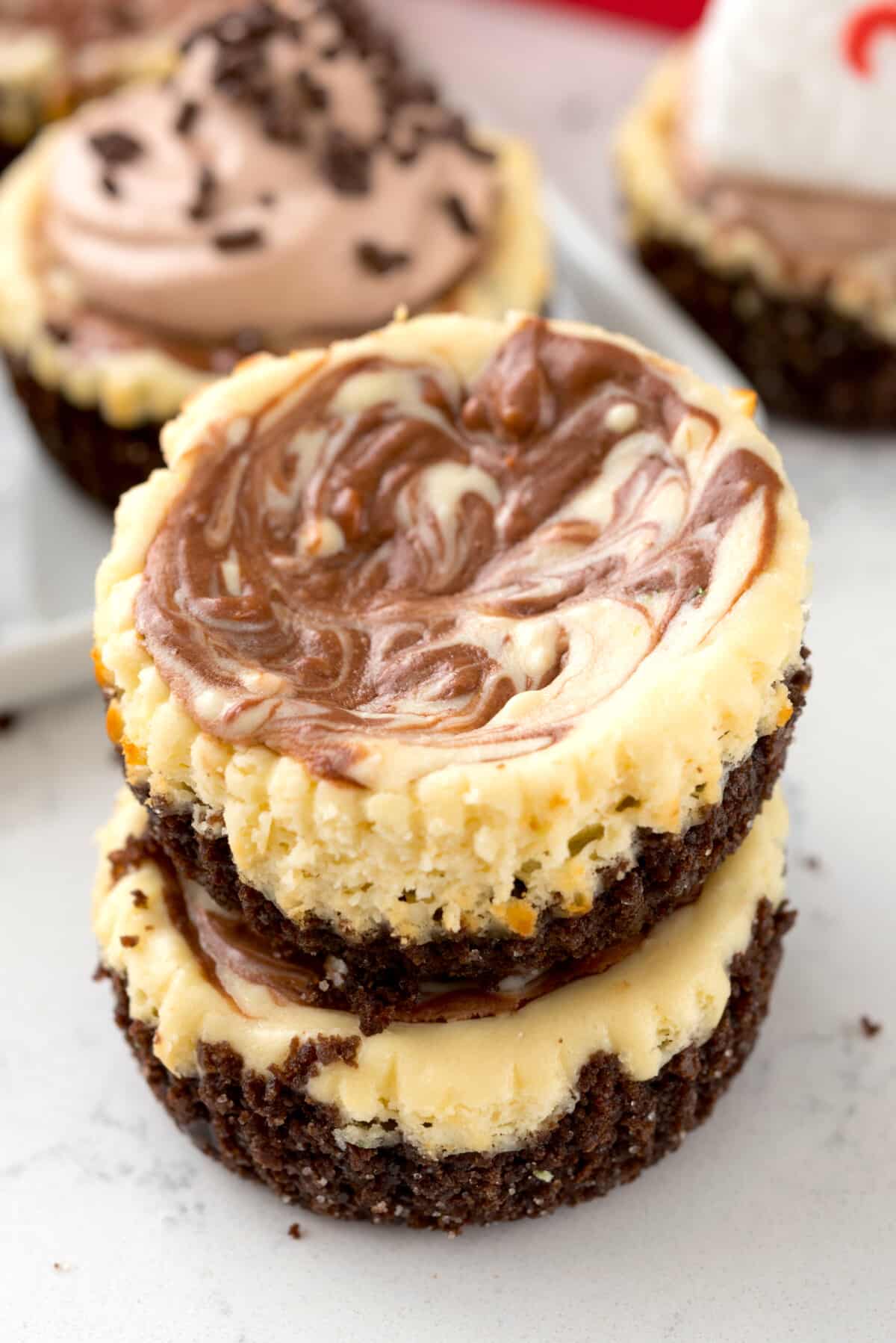 stacked mini circular cheesecakes with white and brown marble on top.