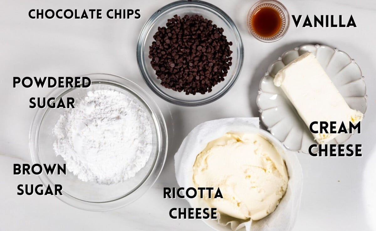 cannoli dip ingredients laid out on a marble countertop.
