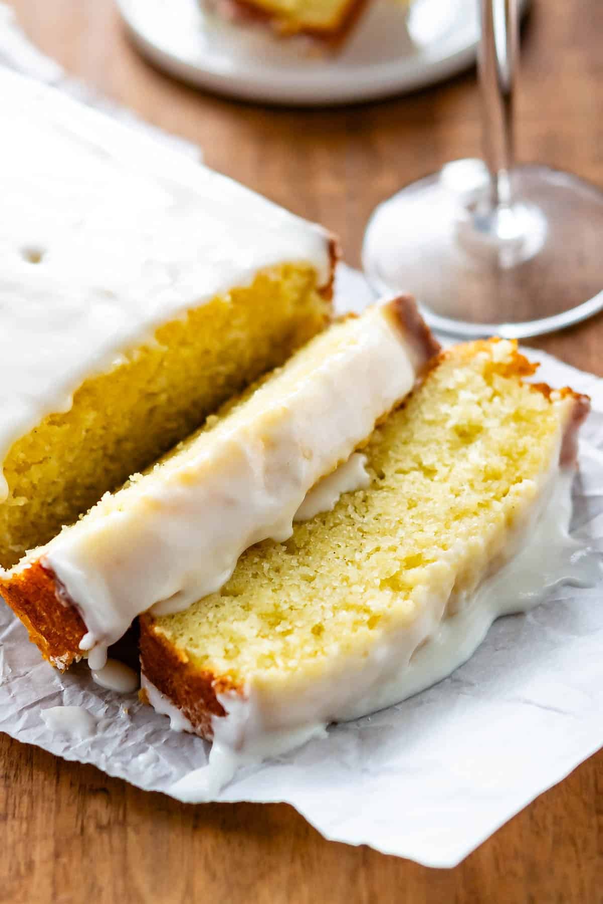 sliced pound cake with icing on top on a white plate.