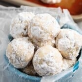 stacked snowballs covered in powdered sugar with chocolate chips baked in.