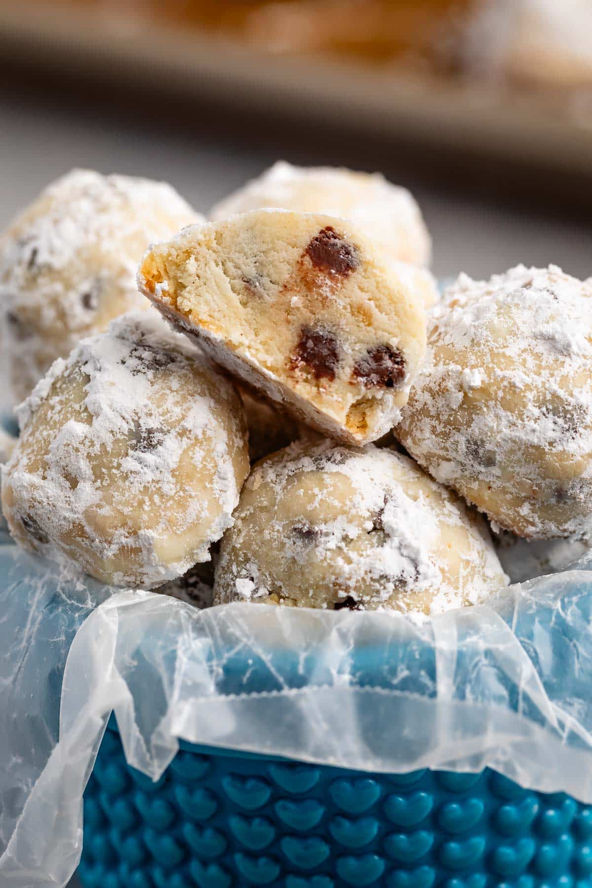 stacked snowballs covered in powdered sugar with chocolate chips baked in.