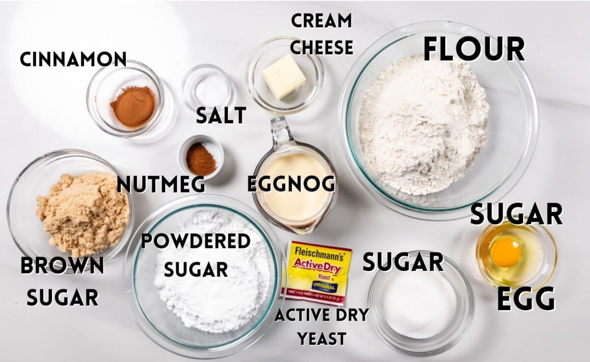 ingredients in eggnog cinnamon rolls laid out on a marble countertop.