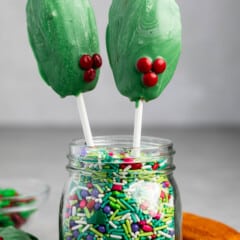 madeleines covered in green chocolate standing up in sprinkles.