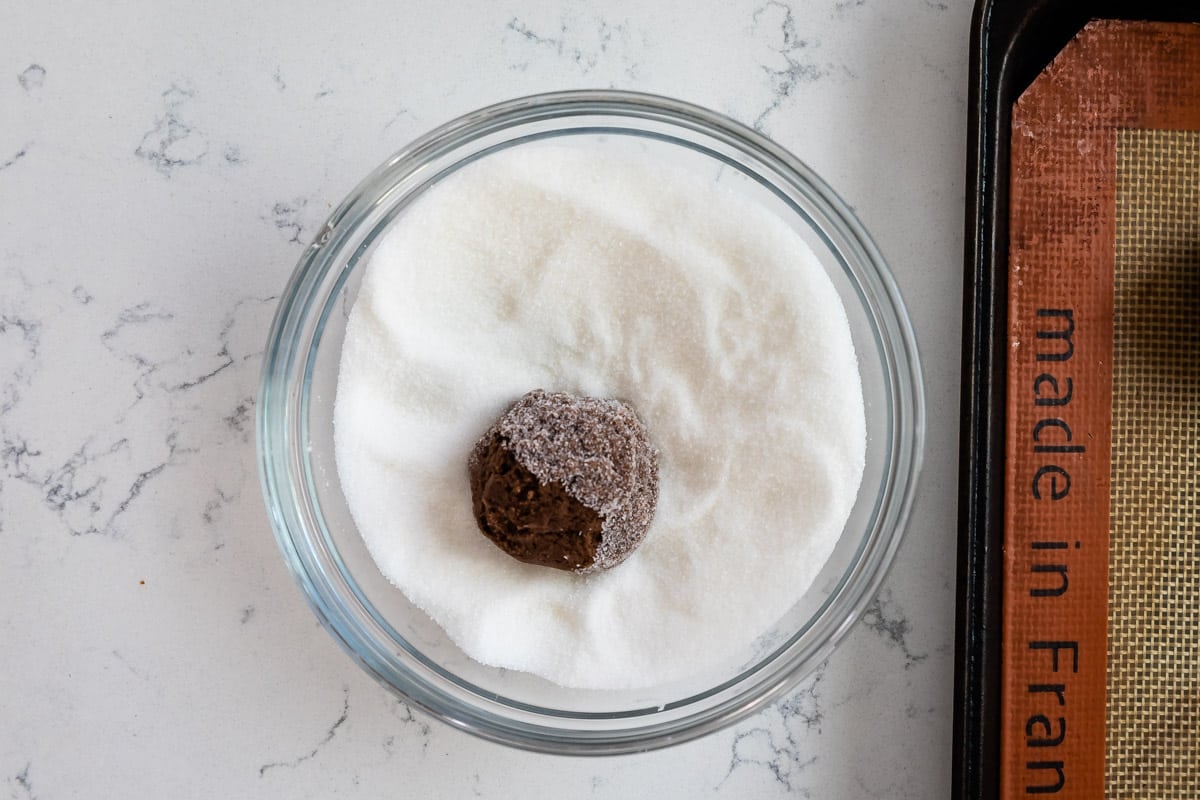 cookie dough in bowl of sugar.