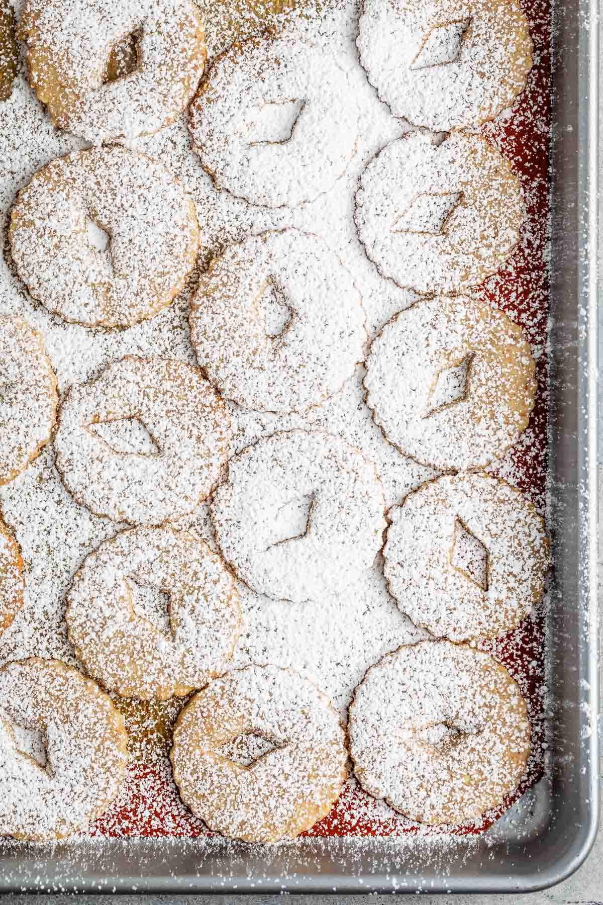 cookie tops on cookie sheet dusted with powdered sugar.