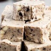 stacked oreo fudge with sliced oreos around the fudge on a blue plate.