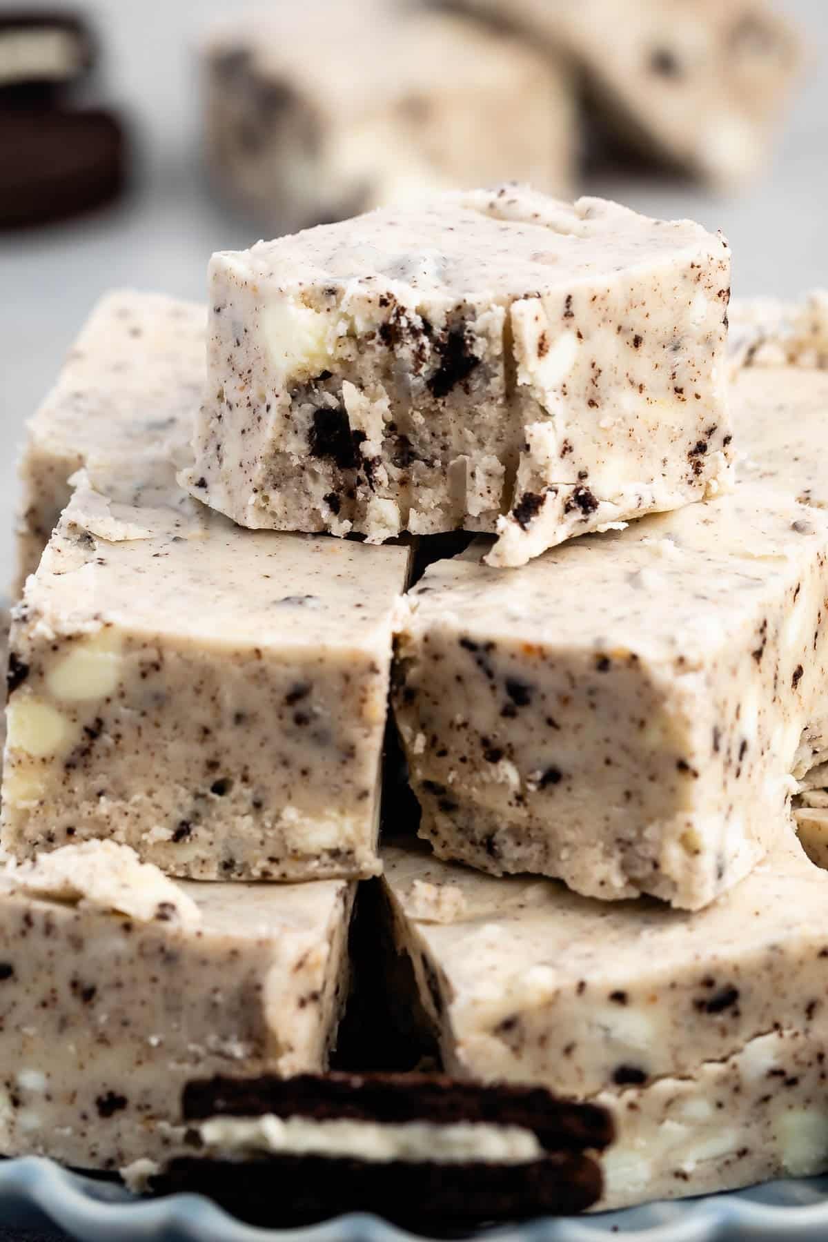 stacked oreo fudge with sliced oreos around the fudge on a blue plate.