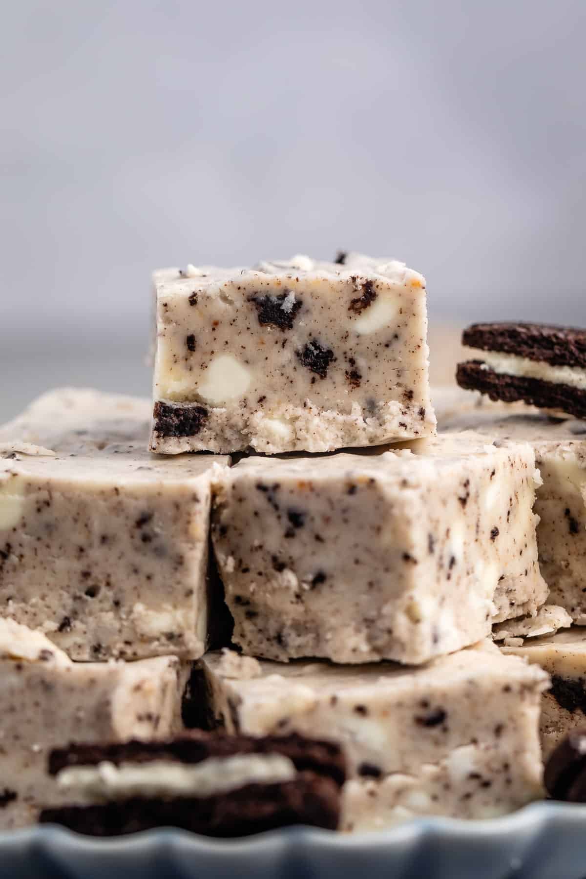 stacked oreo fudge with sliced oreos around the fudge on a blue plate.