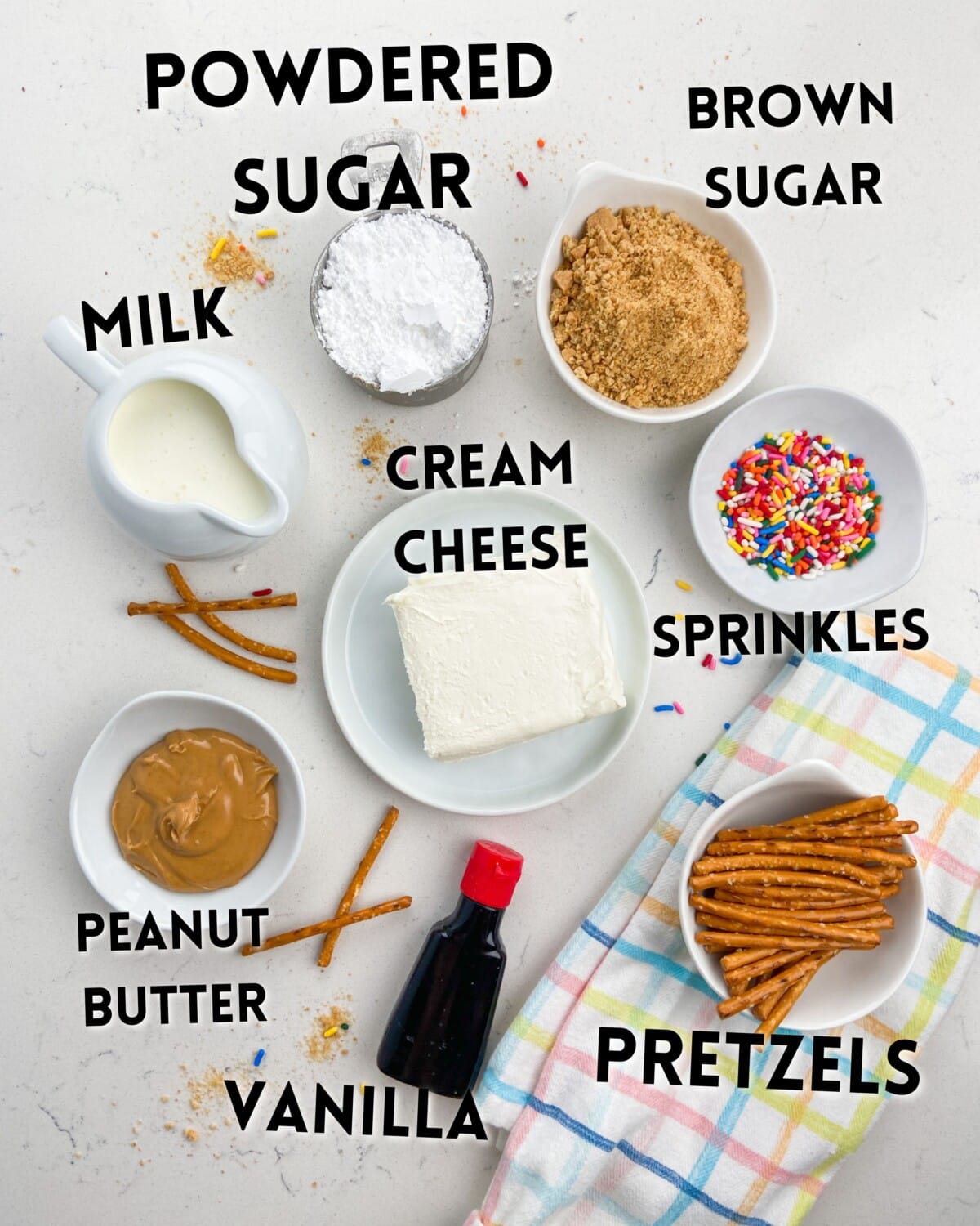 ingredients in peanut butter cheeseball pops laid on a marble counter.