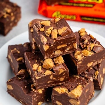 stacked brown reeses fudge on a white plate.